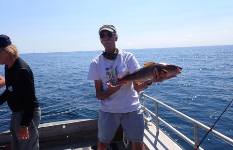 man on a boat holding a fish