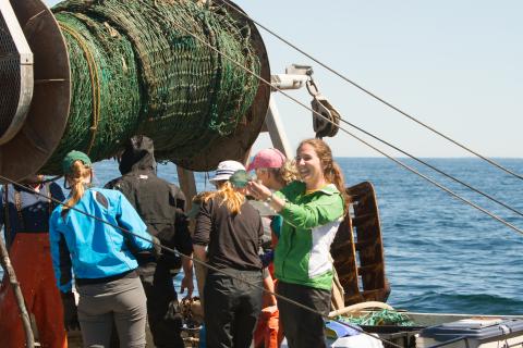 SML students assist during feeding time at UNH's open ocean aquaculture facility