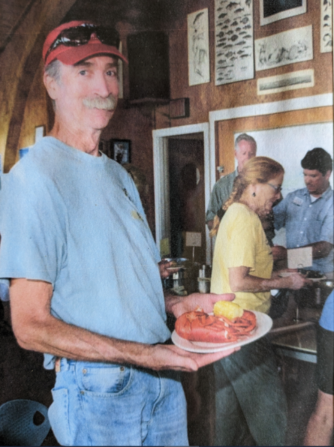 man standing with a lobster dinner