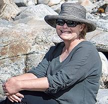 Carol Schwartz with hat on and in front of rocks