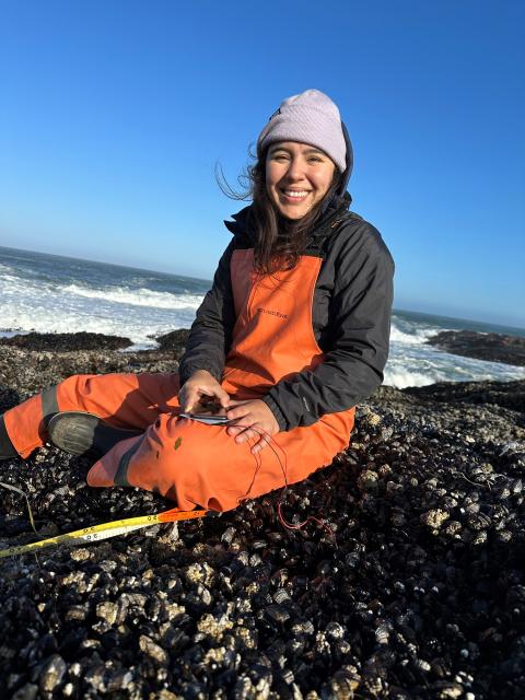a woman on the shore with waders on