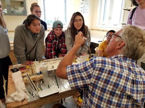a group of shoals students watching Robert give glass demo