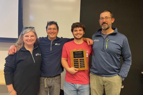 group of people presenting an award to a student