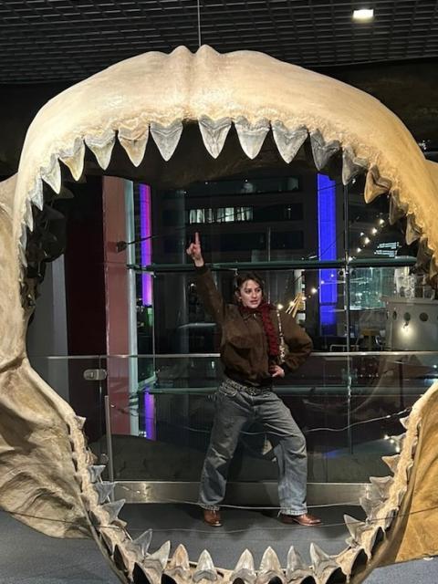 woman in behind giant shark jaws