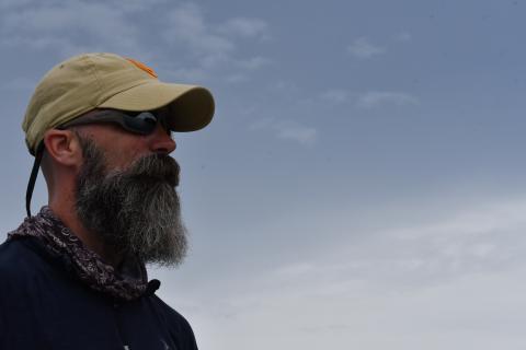 profile of man in hat with sky in background